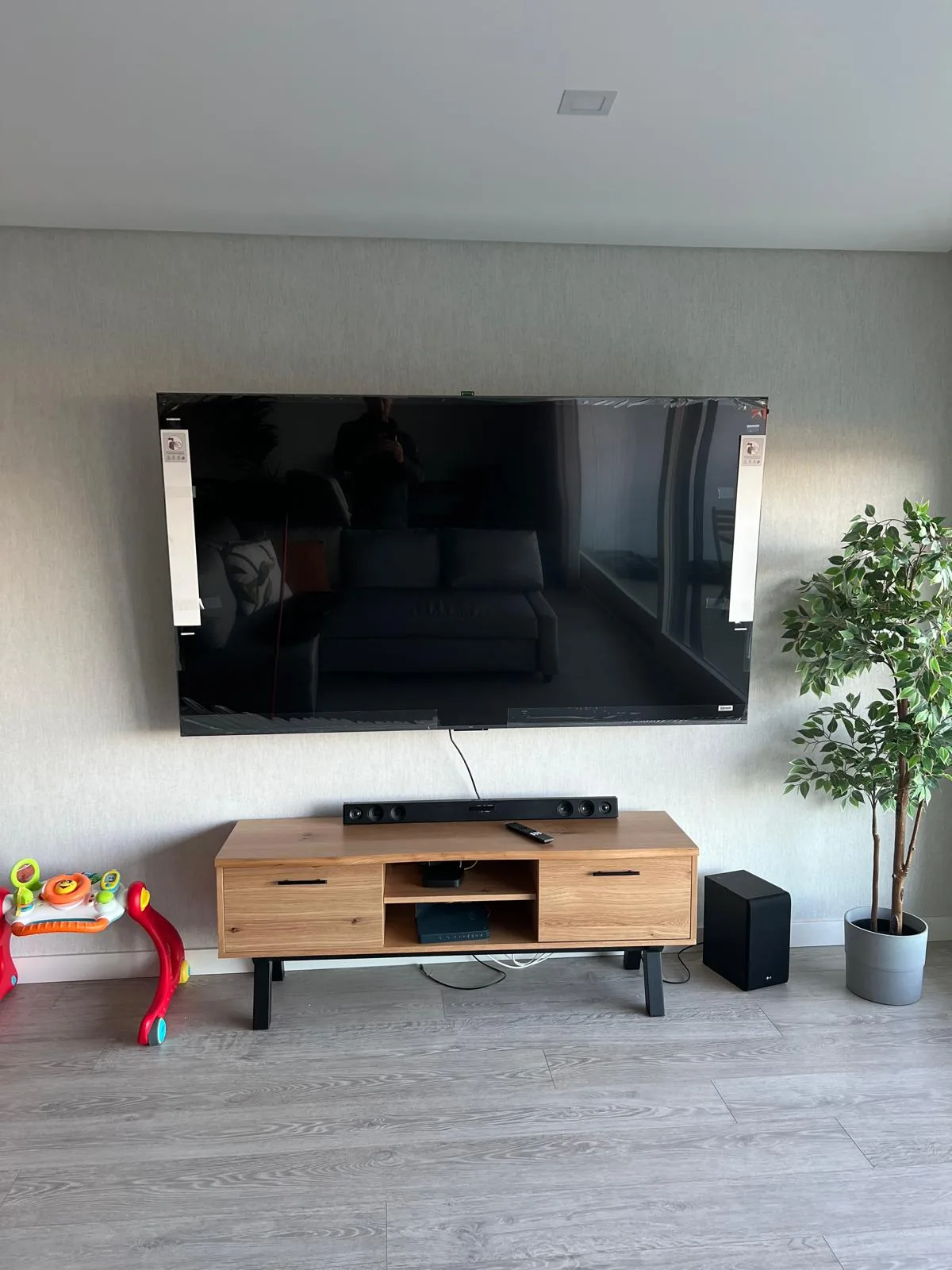 TV murale dans un salon avec meuble et câbles