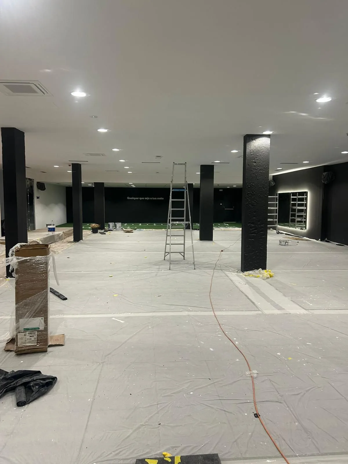 Peinture intérieure dans un grand espace commercial avec piliers noirs et plafond blanc à Lisbonne