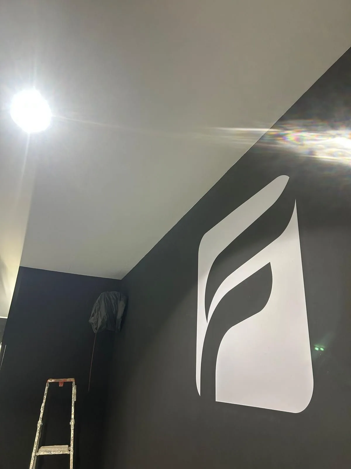 Mur d'accent peint en noir avec logo blanc et finition de plafond